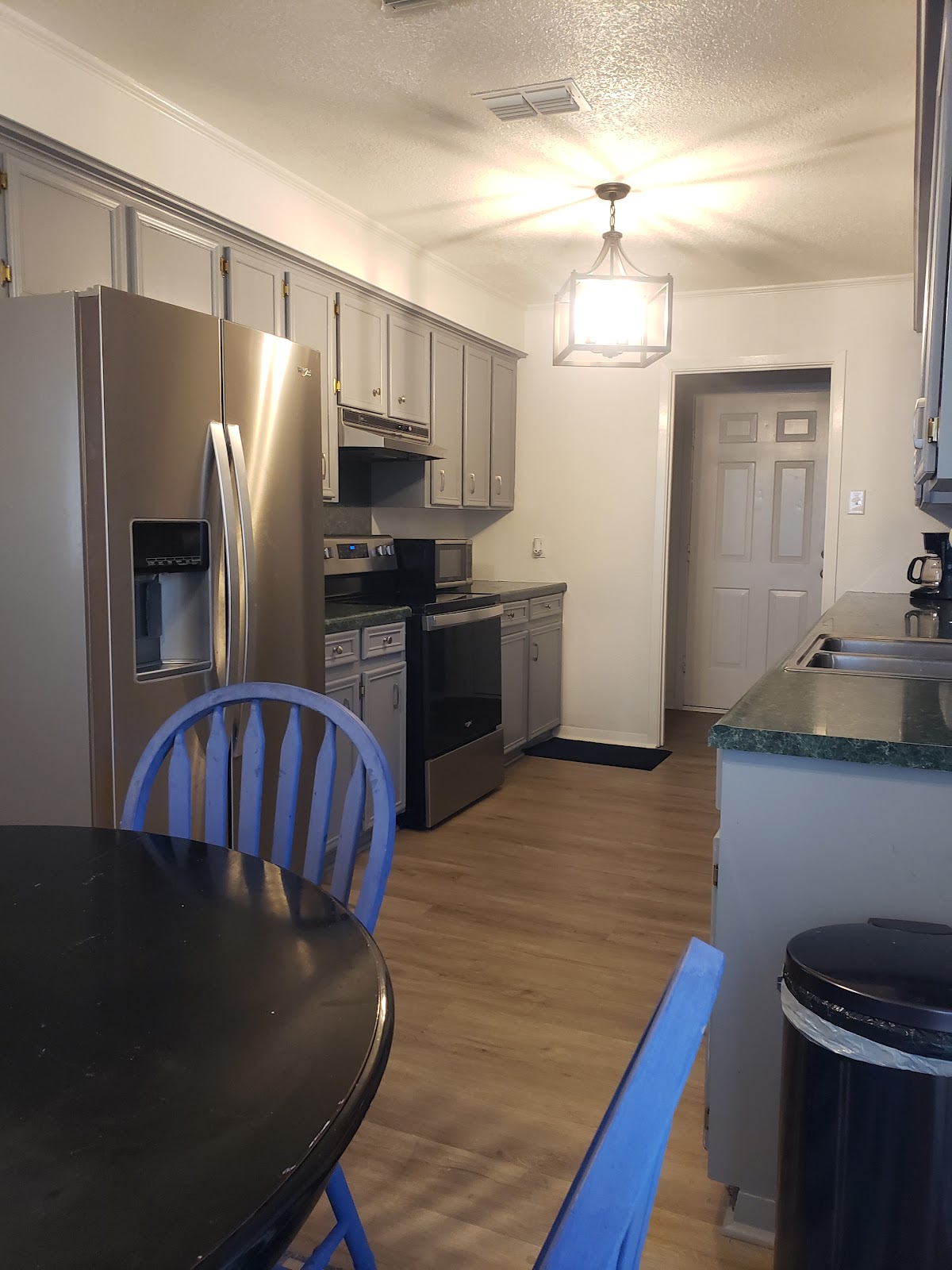 Grey painted kitchen cabinets with a pendant light