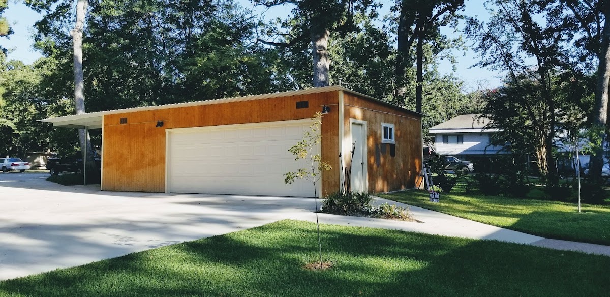 Detached garage with wood siding and white trim